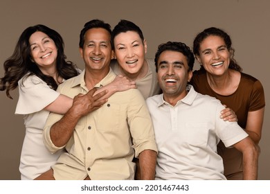 Portrait of a multiethnic group of people laughing together on a neutral background. Stock Photo