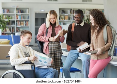 Portrait of multi-ethnic group of students in college library featuring boy in wheelchair in foreground