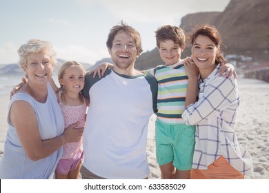 Portrait of multi-generated family embracing at beach during sunny day - Powered by Shutterstock