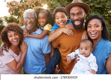 Portrait Of Multi-Generation African American Family Relaxing In Garden At Home Together