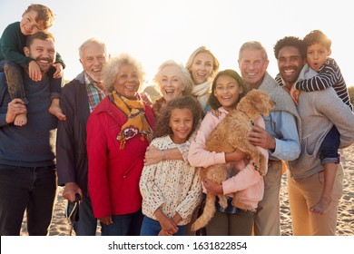 Portrait Of Multi-Generation Family Group With Dog On Winter Beach Vacation