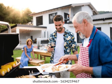Portrait of multigeneration family outdoors on garden barbecue, grilling. - Shutterstock ID 1634219467