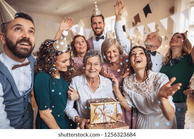 A portrait of multigeneration family with presents on a indoor birthday party. - Powered by Shutterstock