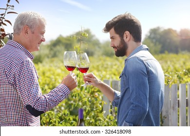 Portrait of multi-generation family working together. Senior winemaker and young professional man standing at vineyard while holding in their hands a glass of wine and tasting it. Small business.
. - Powered by Shutterstock