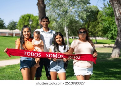 Portrait of multigenerational Peruvian family outdoors wearing a scarf with the words: "Peru we are all" in spanish. Peruvian Independence Day - Powered by Shutterstock