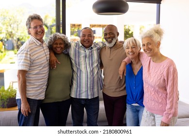 Portrait of multiracial cheerful senior friends with arms around standing in nursing home. Happy, unaltered, friendship, togetherness, support, assisted living and retirement concept. - Powered by Shutterstock