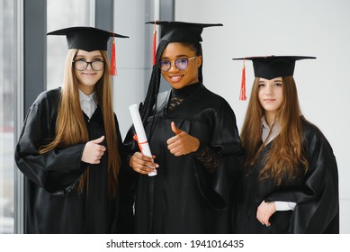 portrait of multiracial graduates holding diploma - Powered by Shutterstock