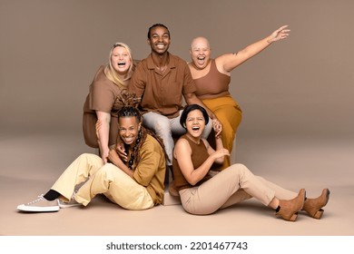 Portrait of a multiracial group of people laughing on a neutral background. Stock Photo