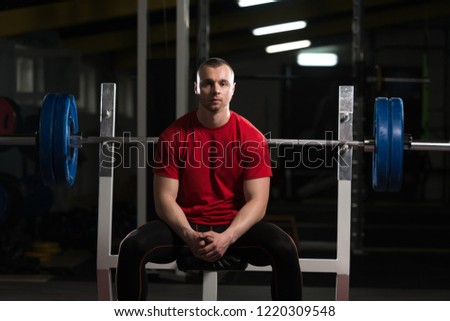 Portrait of Muscular Powerlifter Bodybuilder Fitness Model Sitting Strong Posing After Exercises