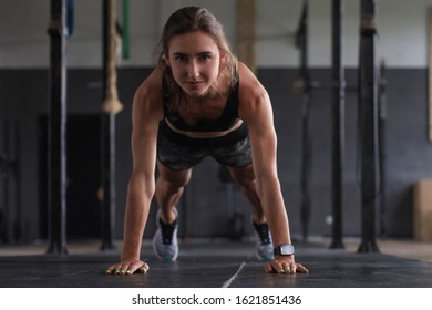 Portrait of a muscular woman on a plank position. - Shutterstock ID 1621851436