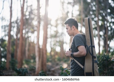 portrait musician man with guitar at the forrest