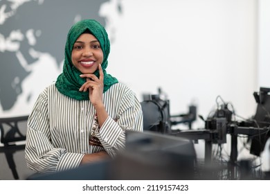 Portrait Of Muslim Black Female Software Developer With Green Hijab Standing At Modern Open Plan Startup Office. Selective Focus 