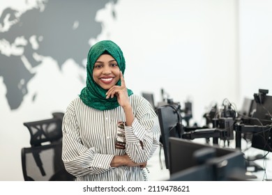 Portrait Of Muslim Black Female Software Developer With Green Hijab Standing At Modern Open Plan Startup Office. Selective Focus 