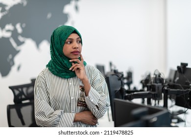 Portrait Of Muslim Black Female Software Developer With Green Hijab Standing At Modern Open Plan Startup Office. Selective Focus 