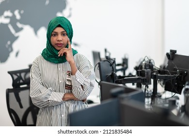 Portrait Of Muslim Black Female Software Developer With Green Hijab Standing At Modern Open Plan Startup Office. Selective Focus 