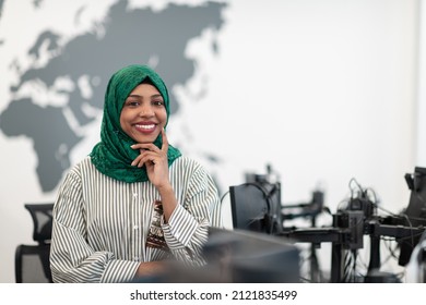 Portrait Of Muslim Black Female Software Developer With Green Hijab Standing At Modern Open Plan Startup Office. Selective Focus 