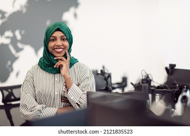 Portrait Of Muslim Black Female Software Developer With Green Hijab Standing At Modern Open Plan Startup Office. Selective Focus 