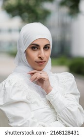 portrait of muslim bride in hijab with diamond ring on finger looking at camera
