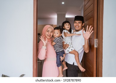 Portrait Of Muslim Family Standing In Front Of Their Front Door House Welcoming Guest At Home During Eid Mubarak Celebration