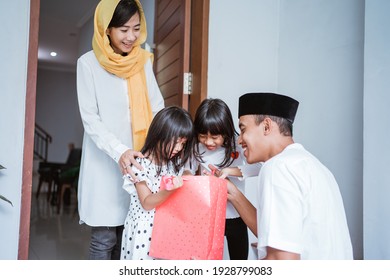 portrait of muslim father giving a gift to his children on eid mubarak