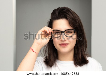 Portrait of myopic girl touching her glasses