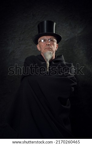 Similar – Man in tails with bouquet and top hat looks into camera