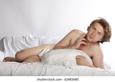 Portrait Of A Naked Man In Bed, Hiding Behind A Pillow. Studio Shot. See More In My Portfolio