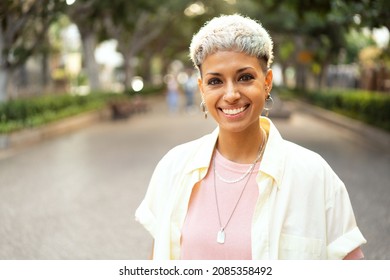 Portrait of natural millenial woman with short blonde hairstyle wearing silver jewelry, earrings and necklace, smiling and looking to the camera. Beautiful girl. Real people emotions. Lifestyle. Stock-foto