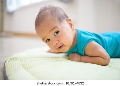 Portrait Of New Born Baby Laying Down On The Bed