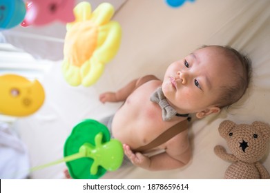 Portrait Of New Born Baby Laying Down On The Bed