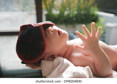 Portrait Of New Born Baby Sun Bathing Under The Morning Sun At Home Next To Window