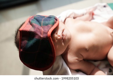 Portrait Of New Born Baby Sun Bathing Under The Morning Sun At Home Next To Window