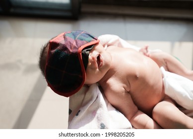 Portrait Of New Born Baby Sun Bathing Under The Morning Sun At Home Next To Window