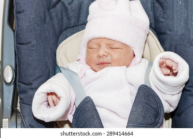 Portrait Of Newborn Baby Girl In A Car Seat