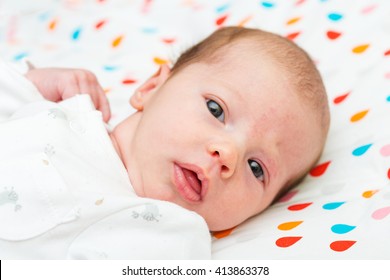 Portrait Of A Newborn Baby Looking At The Camera With Her Eyes Wide Open 