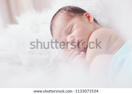 Similar – Newborn baby girl sleeping lying on blanket on bed