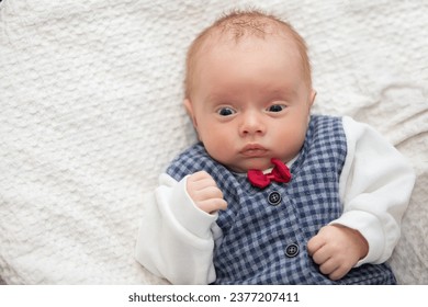 Portrait of a newborn baby wearing an elegant vest with a red bow tie. - Powered by Shutterstock