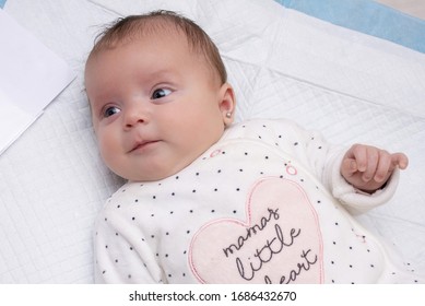 Portrait Of A Newborn Girl With An Earring In Her Ear