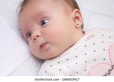 Portrait Of A Newborn Girl With An Earring In Her Ear