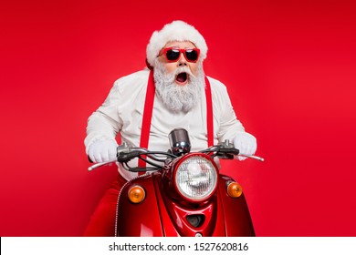 Portrait of nice attractive bearded crazy cheerful cheery funny funky Santa riding motor bike delivering shop orders hurry up isolated over bright vivid shine vibrant red color background - Powered by Shutterstock