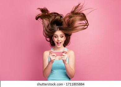 Portrait of nice attractive lovely charming funny focused cheerful cheery straight-haired girl using cell having fun free time ideal silky hair flying isolated on pink pastel color background