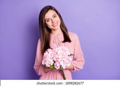 Portrait of nice cute cheerful girl holding in hands pink flowers isolated over bright violet color background