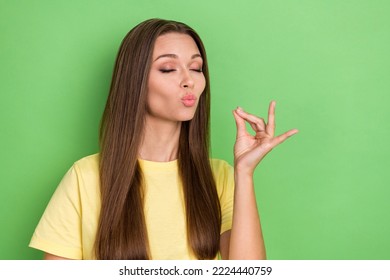 Portrait Of Nice Cute Gorgeous Girl With Straight Hairstyle Dressed Yellow T-shirt Tasting Imaginary Food On Green Color Background