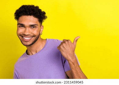 Portrait of nice friendly positive man beaming smile direct finger empty space proposition isolated on yellow color background - Shutterstock ID 2311459045