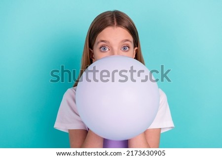 Portrait of nice little girl blowing inflate air balloon prepare decoration isolated on turquoise color background