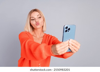 Portrait of nice young girl phone selfie kiss orange cardigan isolated on grey color background - Powered by Shutterstock