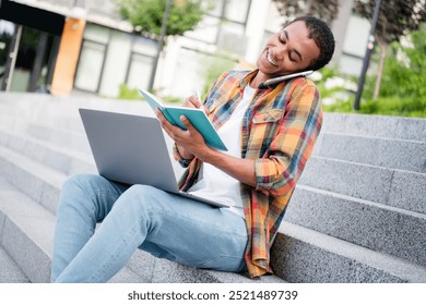 Portrait of nice young man sit stairs speak phone write notepad laptop wear shirt buildings city center outdoors - Powered by Shutterstock