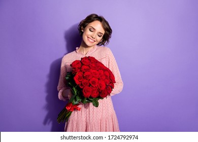 Portrait of nice-looking attractive lovely lovable charming winsome feminine cheerful dreamy girl holding in hands roses isolated on bright vivid shine vibrant lilac violet purple color background