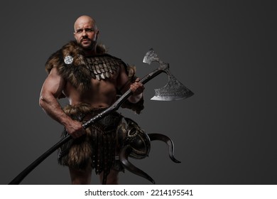 Portrait Of Nordic Warrior With Muscular Build Dressed In Armor Holding Axe.