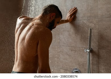 Portrait Of Nude Bearded Guy Enjoying Shower Standing Under Steaming Hot Water Washing Body And Relaxing In Modern Bathroom At Home. Male Beauty, Bodycare And Everyday Hygiene For Men Concept